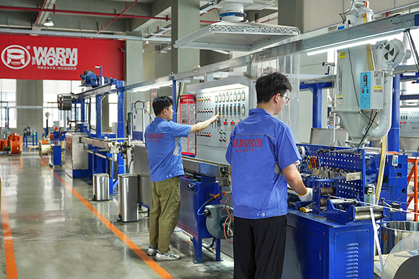 工人在操作電伴熱帶護套擠出設備。 環瑞電熱供圖